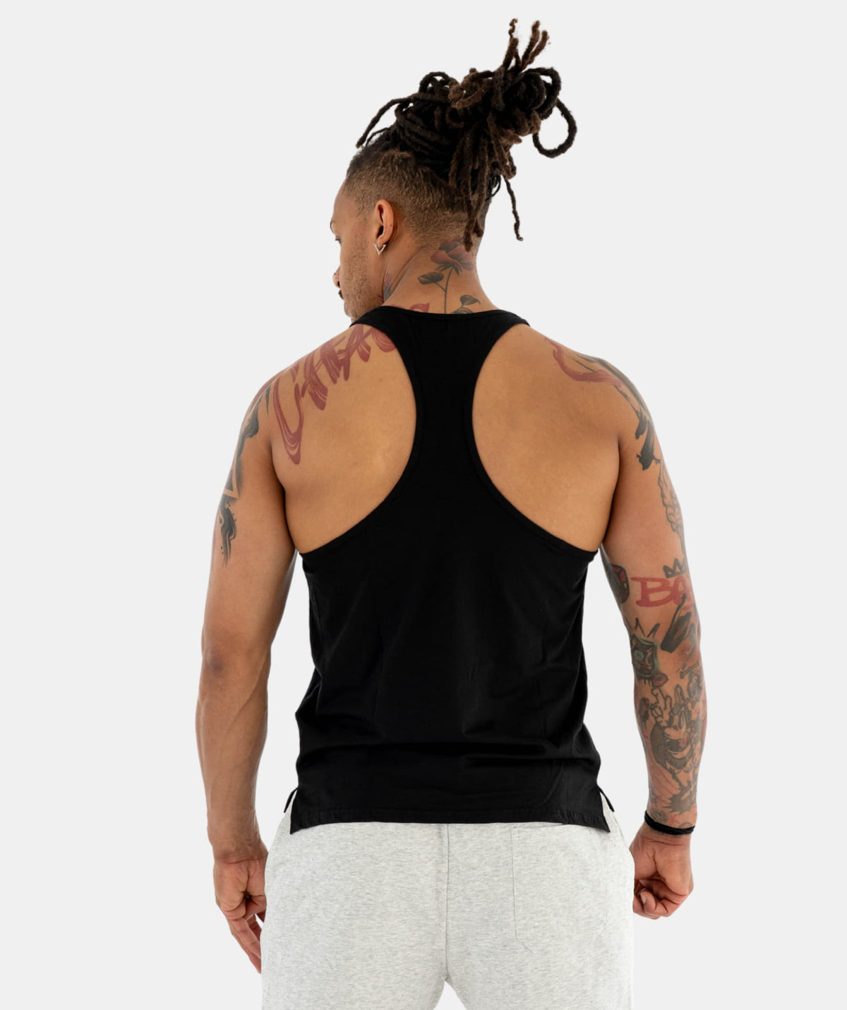 Man a black tank top and white pants