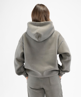 Rear view of women’s grey oversized hoodie showing hood structure and smooth back panel