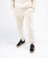 Front view: Interpro Fitness Men’s Crème Joggers, front view showing tapered fit and stylish pose with hands in pockets.