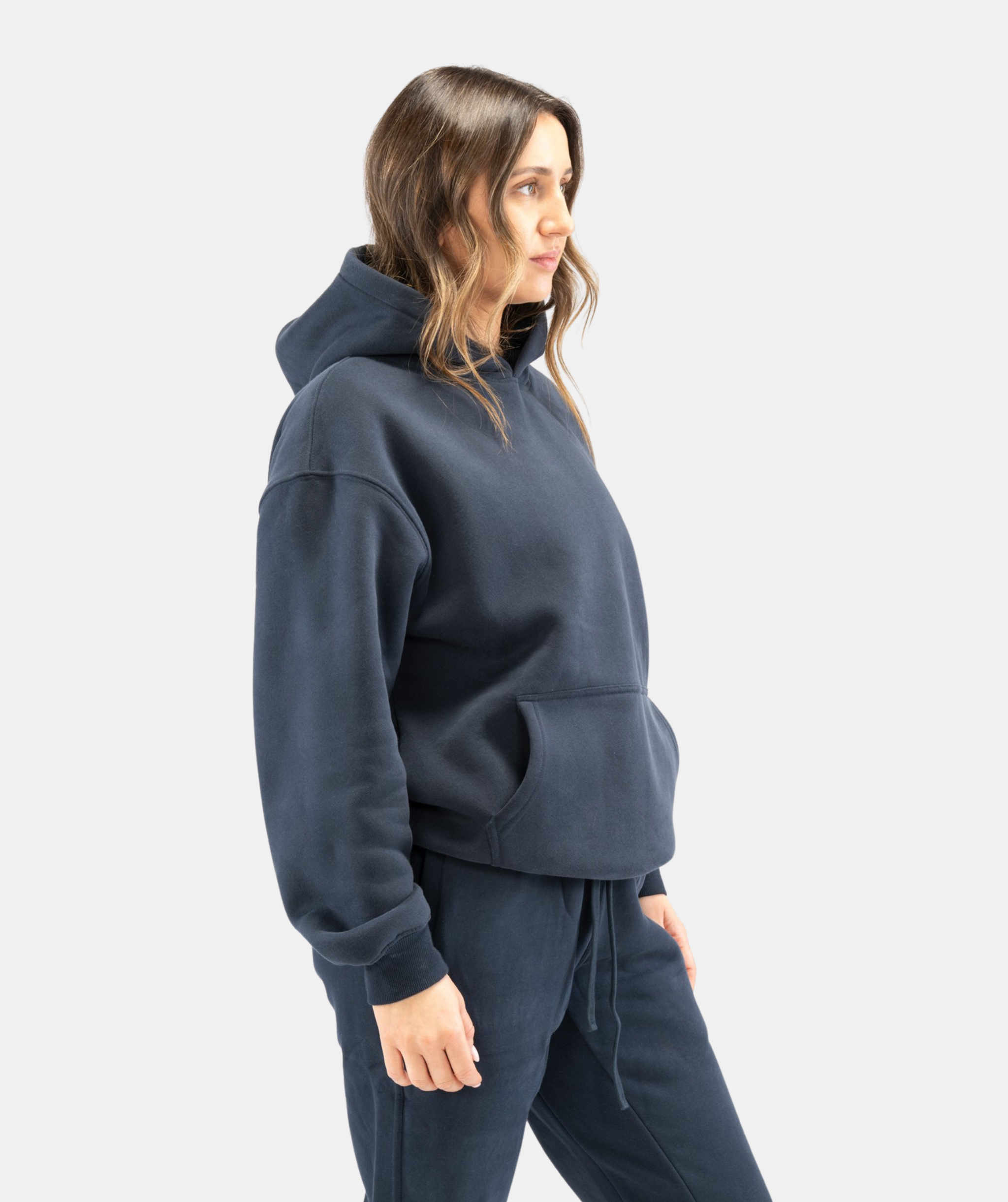 Side-profile full-body shot of women’s navy blue hoodie showing relaxed fit and ribbed cuffs