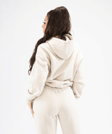 Rear view of cream pullover hoodie showing hood shape and smooth seam detailing