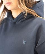 Close-up of Interpro Fitness IF silicone logo on women’s navy blue hoodie showing raised detailing