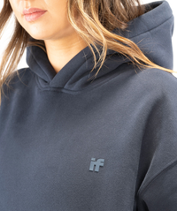 Close-up of Interpro Fitness IF silicone logo on women’s navy blue hoodie showing raised detailing