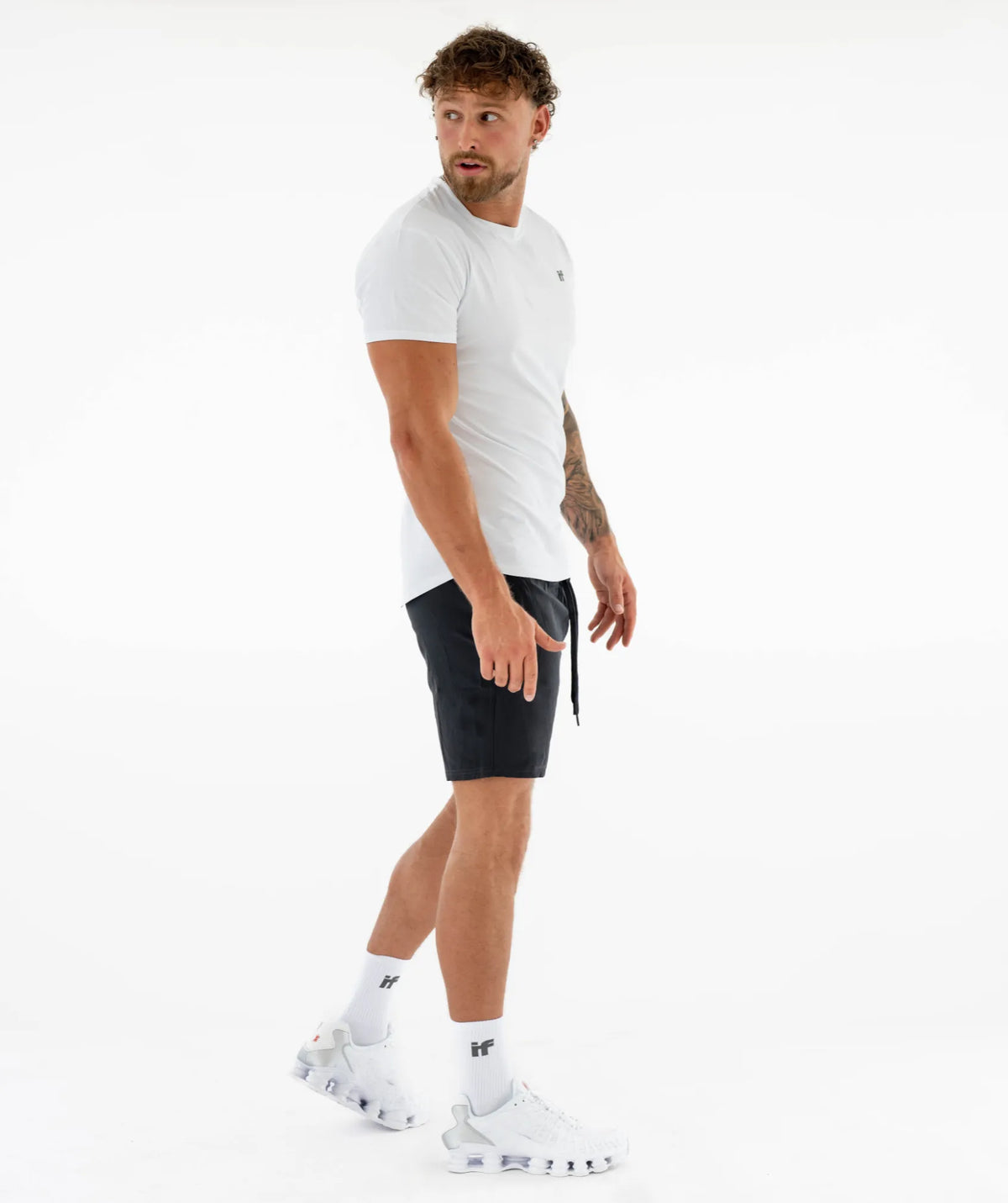 white t-shirt, black shorts, and white sneakers