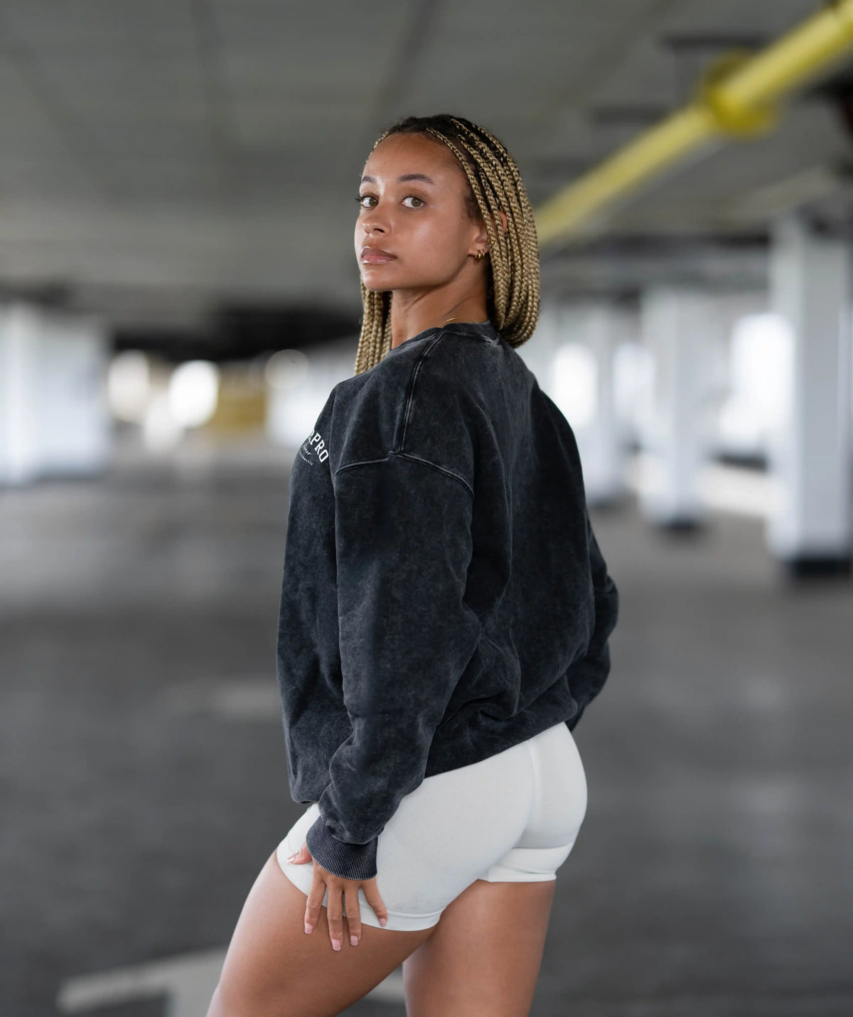 Woman wearing a black sweatshirt and white shorts