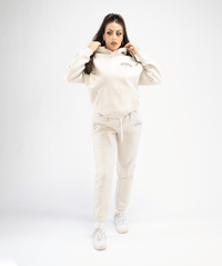 Full-body outfit featuring women’s cream pullover hoodie styled with athleisure wear, front angle