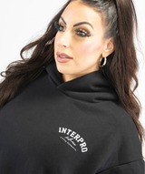 Close-up of fabric texture on black oversized hoodie featuring soft cotton-blend material including logo