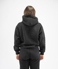 Rear view of women’s black pullover gym hoodie showing hood structure and clean back panel