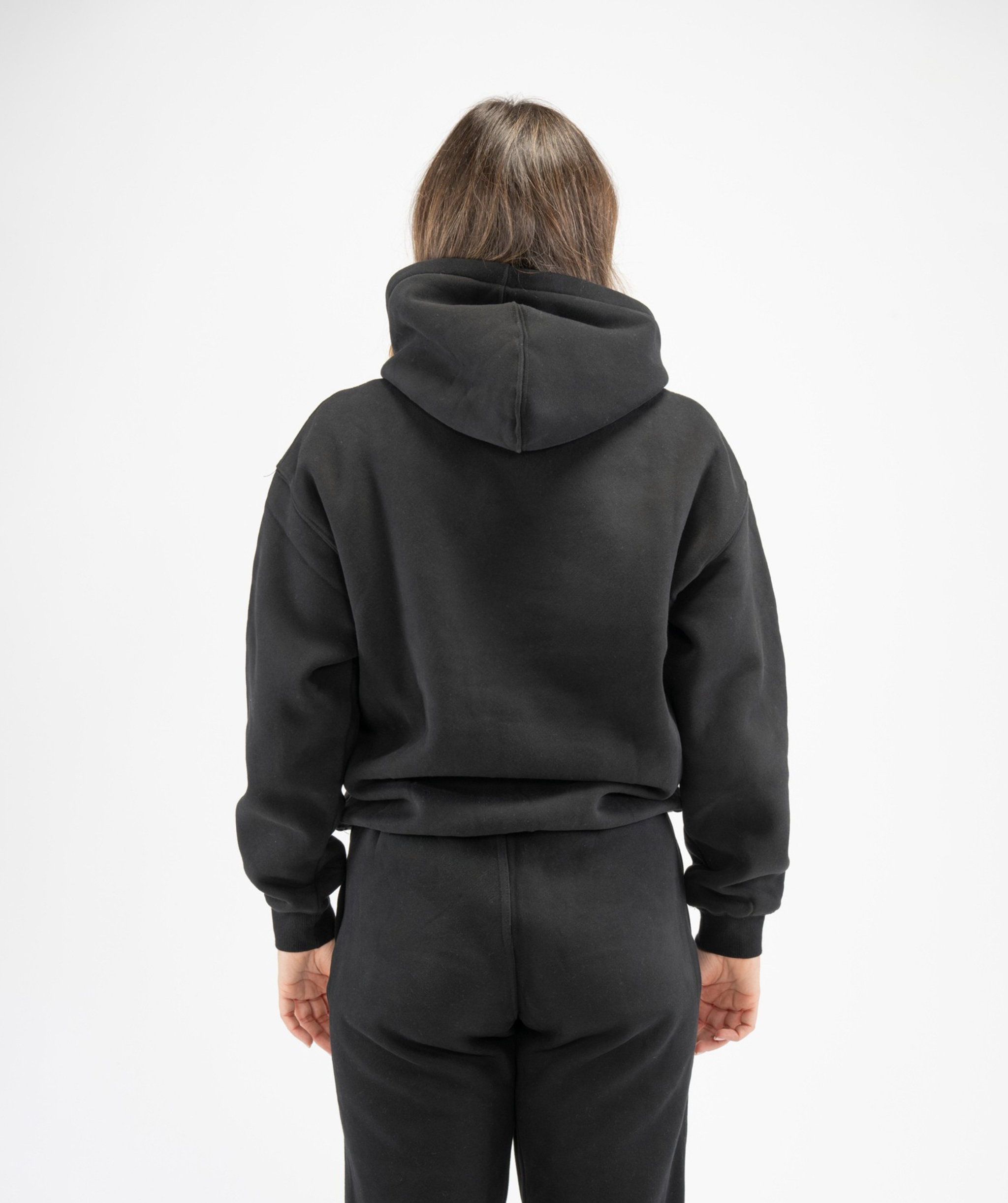 Rear view of women’s black pullover gym hoodie showing hood structure and clean back panel