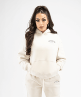 Front view of women’s creme pullover hoodie showing relaxed fit and minimalist design