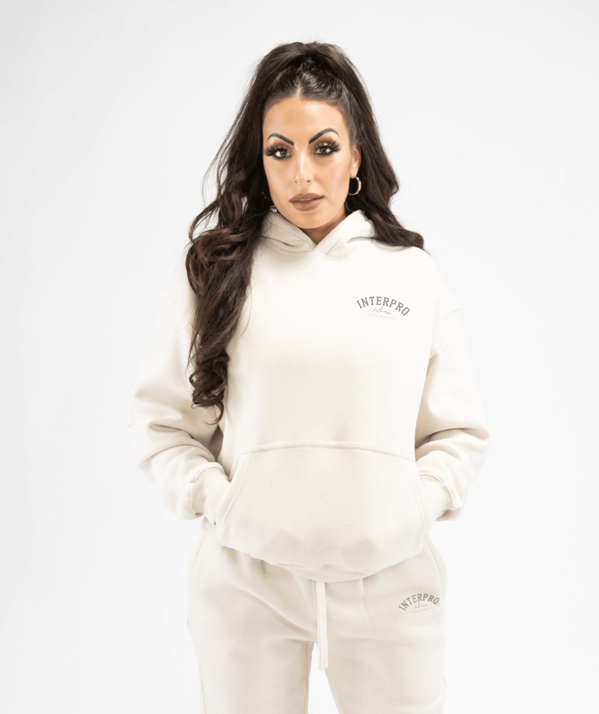 Front view of women’s creme pullover hoodie showing relaxed fit and minimalist design