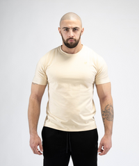 Male model wearing Interpro Fitness Men’s Beige Gym Tee with fitted athletic shape.