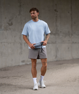 Full body shot of Interpro Fitness Light blue oversized men’s gym t-shirt styled for workout