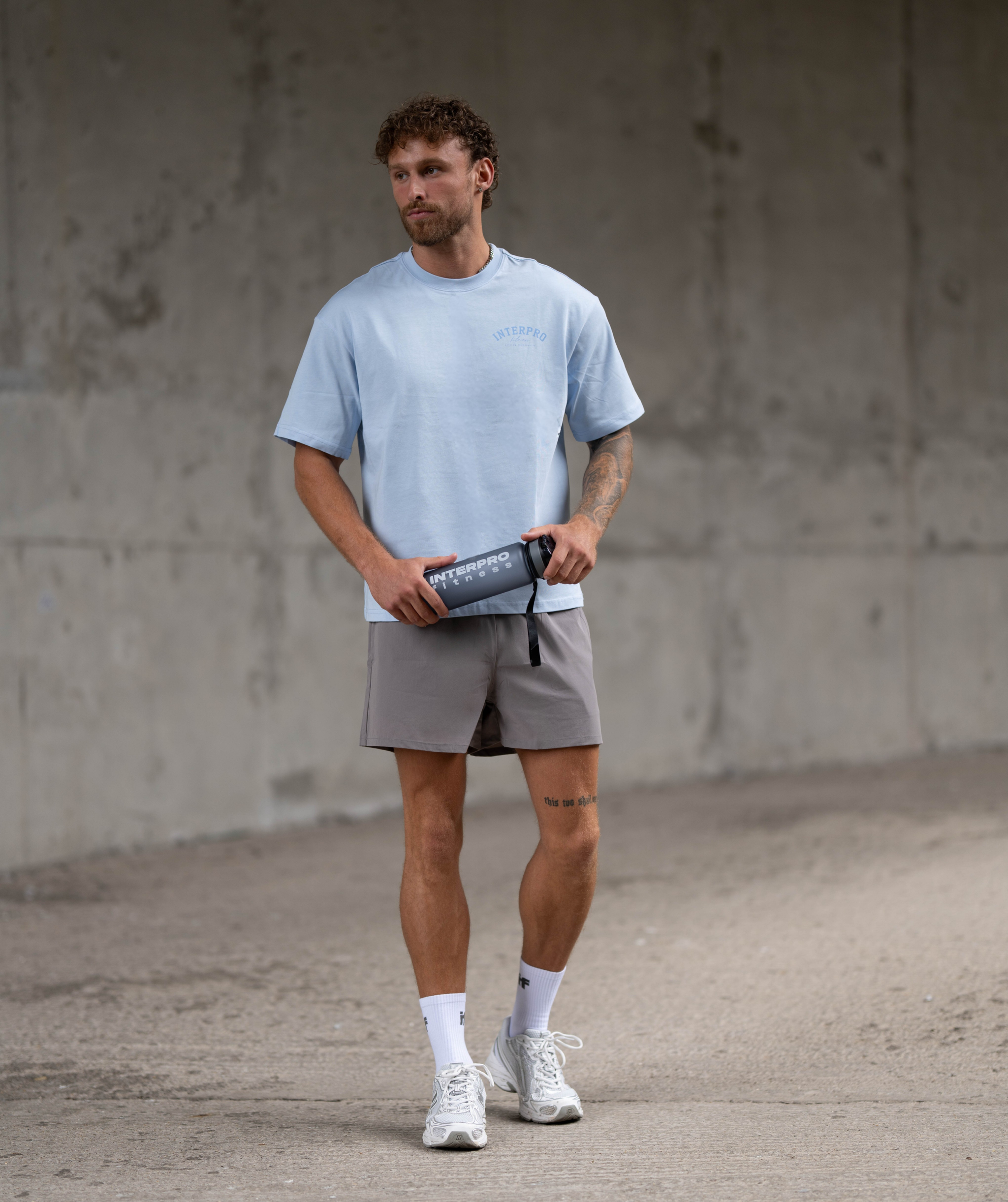 Full body shot of Interpro Fitness Light blue oversized men’s gym t-shirt styled for workout