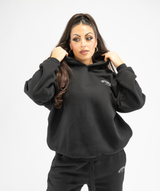 Front-facing shot of black oversized women’s hoodie highlighting loose silhouette and casual streetwear style