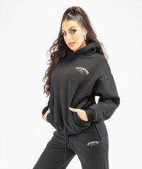 Side angle of women’s black oversized hoodie showing roomy fit and soft drape