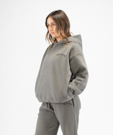 Side angle of women’s grey oversized Interpro Fitness hoodie showing dropped shoulders and roomy fit