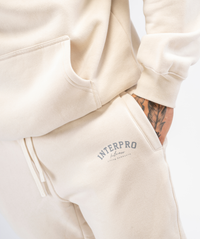 Close-up of mens creme joggers fabric and stitching, pocket and logo from Interpro Fitness.