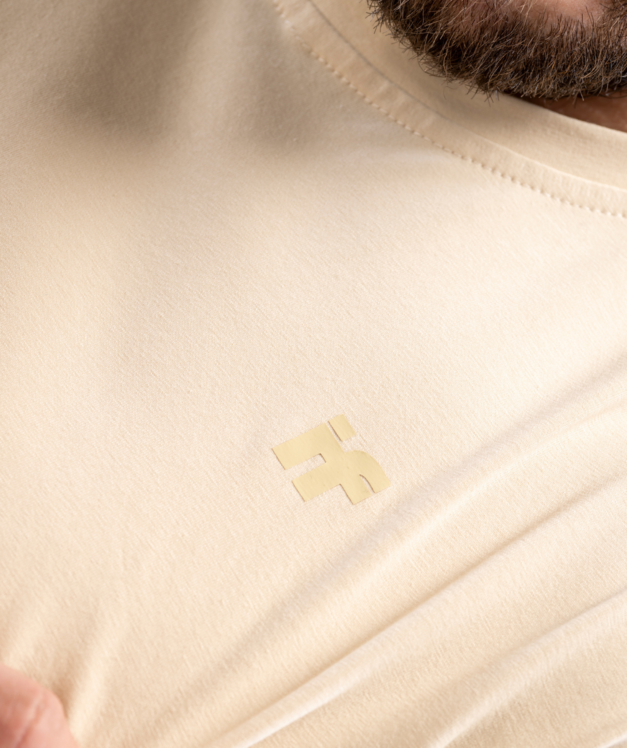 Colour-matched IF logo close-up on beige training tee for men