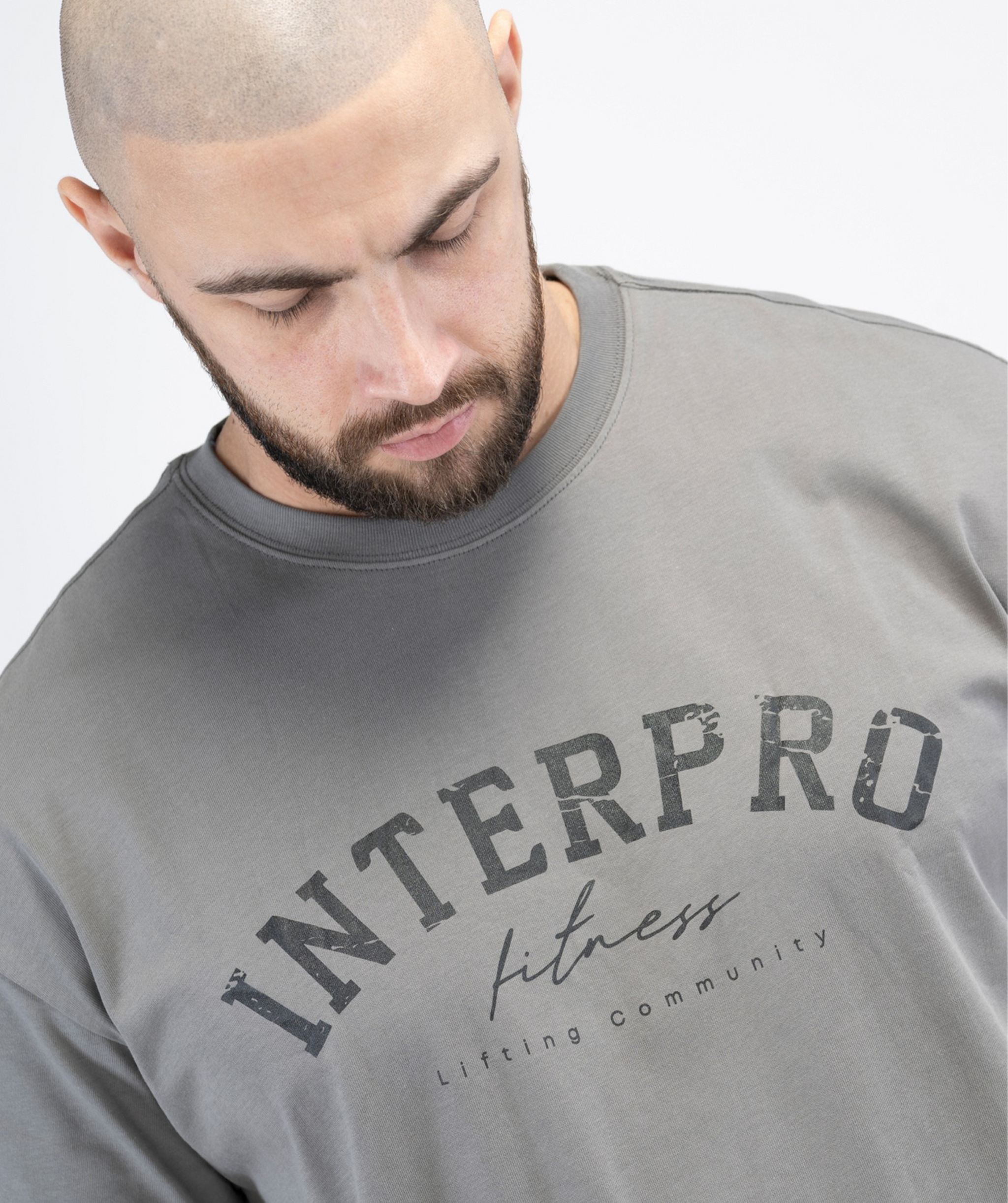 Close-up of chest logo and material on Interpro Fitness grey oversized workout top