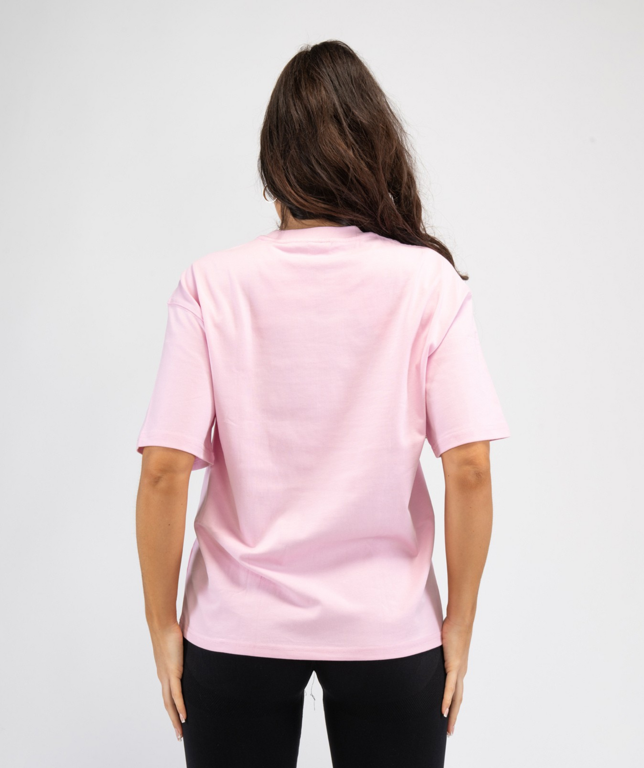 Rear view of women’s oversized gym tee showing straight hem and smooth back panel