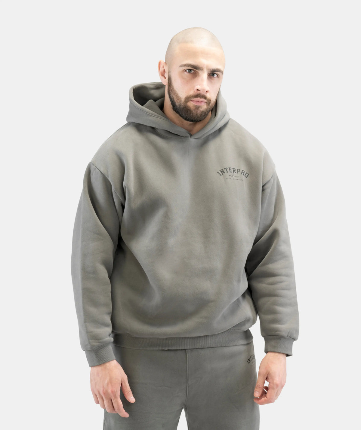Man wearing a gray hoodie with a brand logo