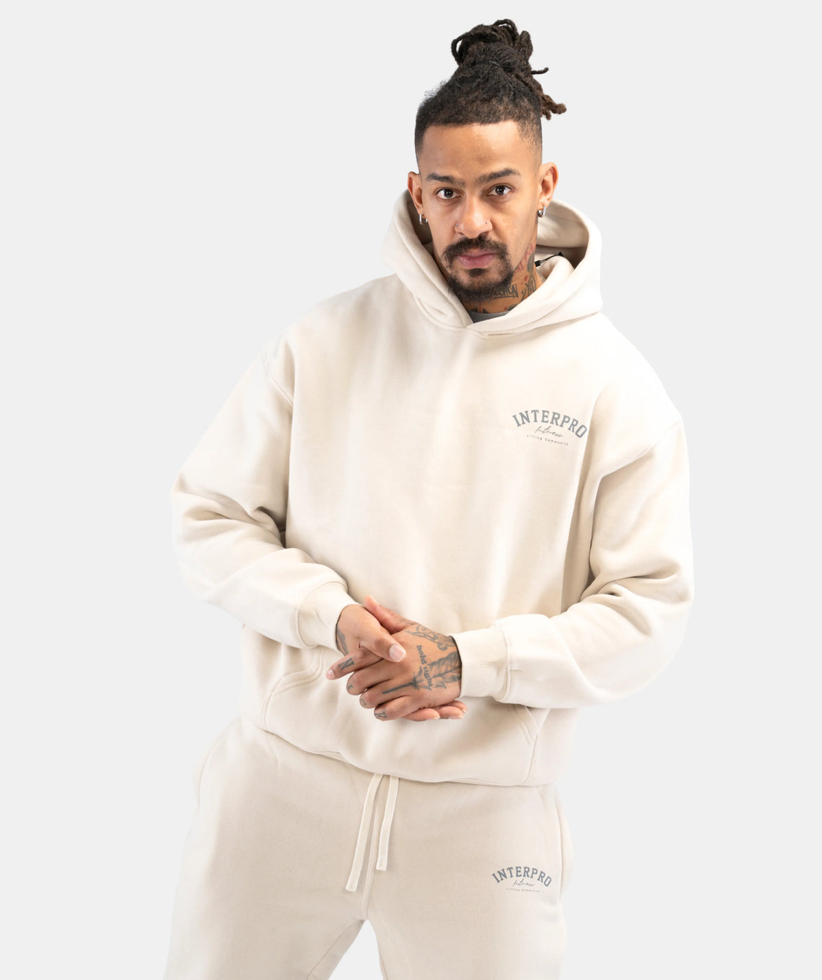 Man wearing a cream hoodie with 'Interpro' branding 
