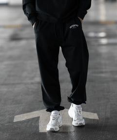 wearing black pants with a brand logo
